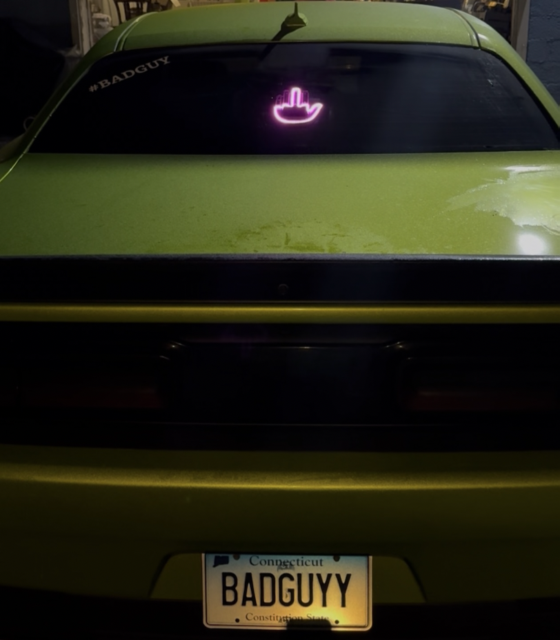 Rear of a lime green car with a BADGUYY plate
